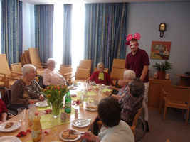 Menschen feiern gemeinsam mit Essen und Trinken in einem festlichen Raum.