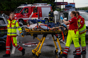 Rettungskräfte transportieren eine Person auf einer Trage in einer Notfallsituation.