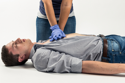 Eine Person führt Herzmassage an einer liegenden Person durch.