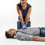 Eine Person führt Herzmassage an einer liegenden Person durch.