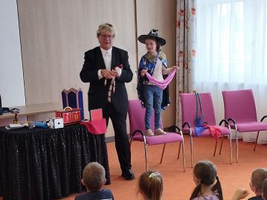 Ein Zauberer führt eine Vorstellung für Kinder in einem Gemeinschaftsraum auf.