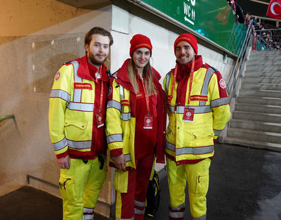 Drei Mitarbeiter:innen des Samariterbundes stehen gemeinsam im Ernst-Happel-Stadion.
