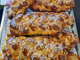 Eine Sammlung von frisch gebackenem Zopf-Brot mit Mandeln und Zuckerstreuseln.