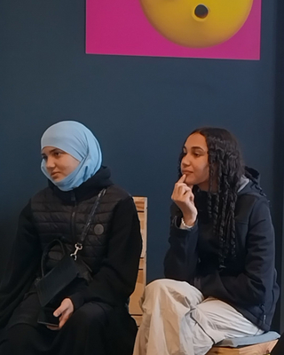 Zwei Mädchen lauschen gespannt einem Vortrag über mögliche Berufsfelder in der IT-Branche.