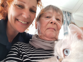 Eine Frau mit rotem Haar und eine ältere Dame halten eine Katze.