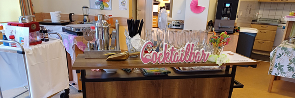 Cocktailbar mit Gläsern und Dekoration in einem hellen Raum.