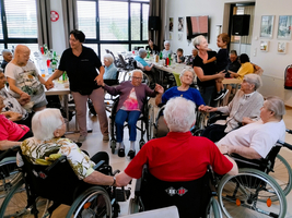 Ältere Menschen in Rollstühlen haben ein geselliges Treffen in einem Raum.
