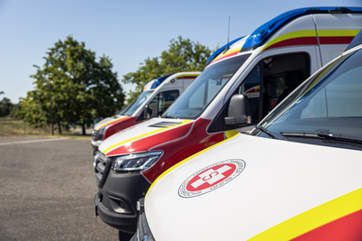 Verschiedene Rettungswagen stehen auf einem Parkplatz nebeneinander.