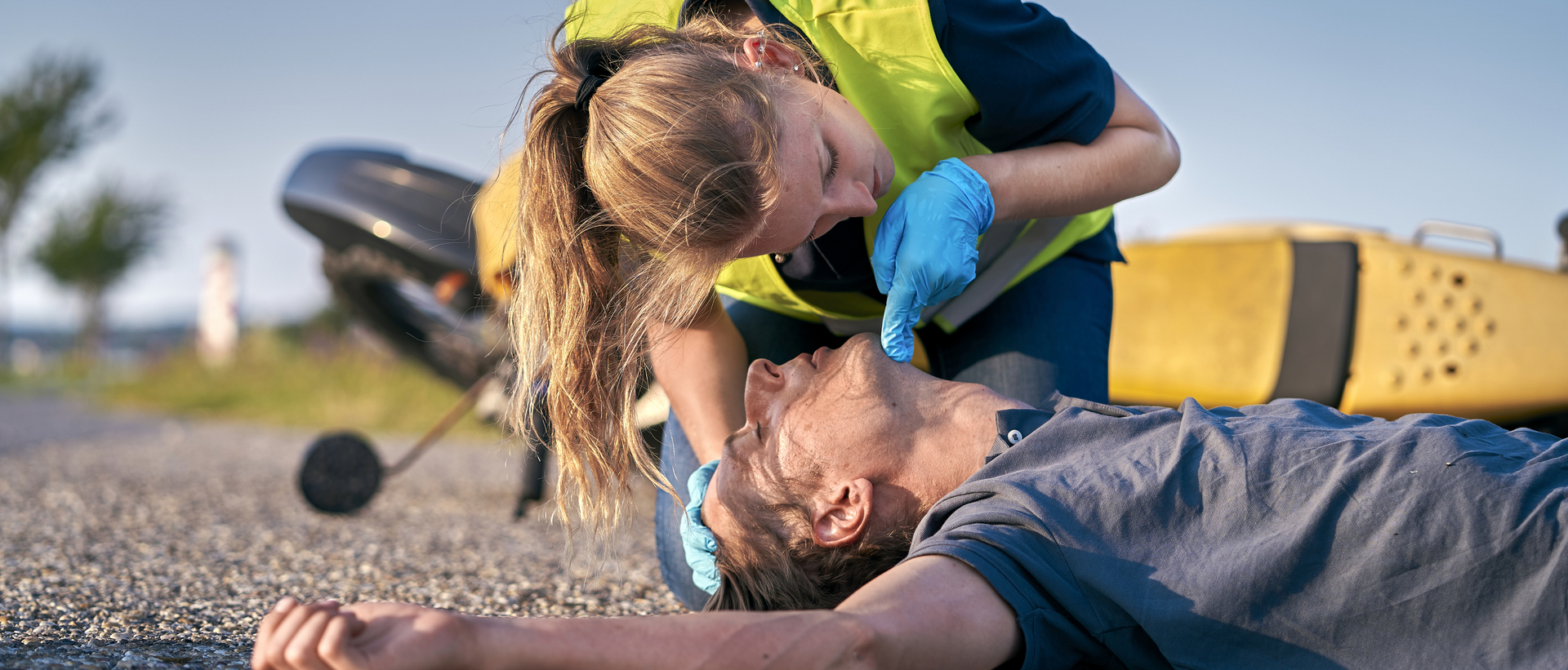 Eine Person leistet Erste Hilfe an einem verletzten Mann auf dem Boden.