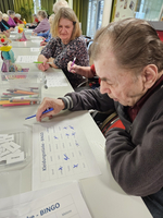 Senioren spielen Bingo mit Markierungen auf ihren Spielkarten.
