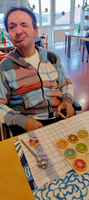 Ein Mann in einem Rollstuhl sitzt an einem Tisch mit bunten Keksen.