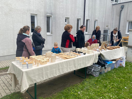 Ein Markttisch mit handgefertigten Holzartikeln und mehreren Personen, die stöbern.