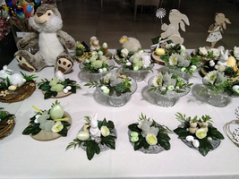 Dekorative Osternester mit Hasenfiguren und grünen Eiern auf einem Tisch.