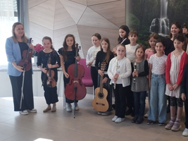 Gruppe von Kindern mit Musikinstrumenten, die für ein Konzert bereitstehen.