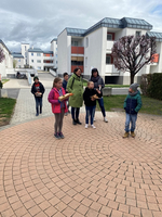 Eine Gruppe von Kindern steht in einem Wohnbereich und hält Gegenstände in der Hand.