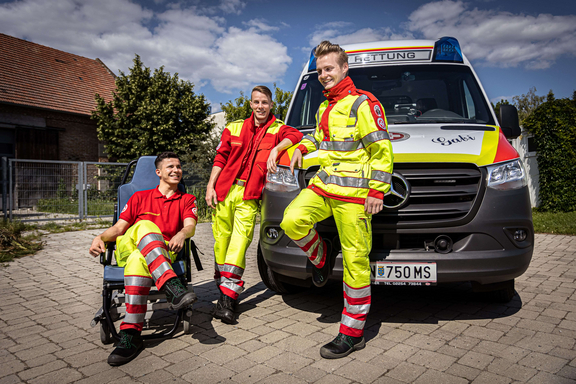 3 Sanitäter vor Krankentransportwagen