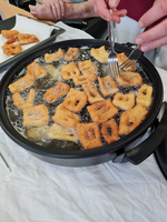 Frittierte Teigstücke werden in einer Pfanne mit heiße Öl zubereitet.