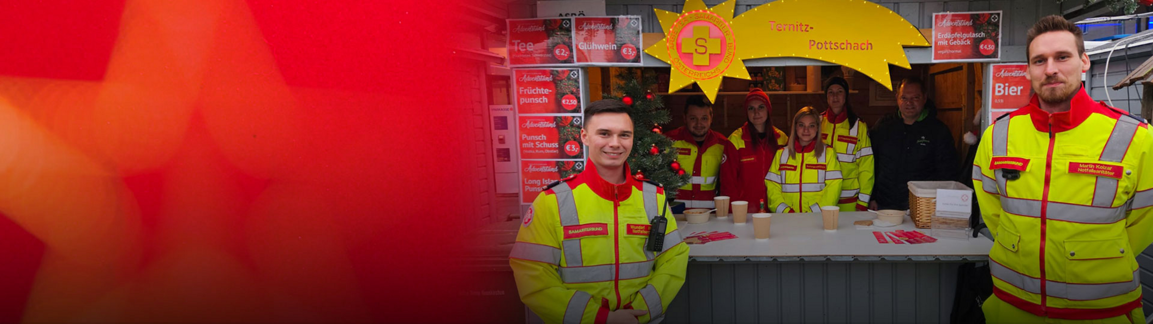 Mitarbeiter im reflektierenden Schutzanzug stehen an einem Weihnachtsstand.