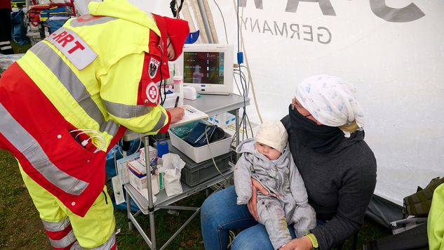  Emergency Medical Team (EMT) betreut Mutter mit Kind