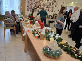Weihnachtsmarkt mit festlich dekorierten Tischen und vielen Leckereien.