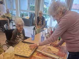 Ältere Frauen backen gemeinsam Plätzchen in einem gemütlichen Raum.