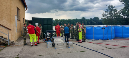 Einsatzkräfte besprechen Maßnahmen bei einem Rettungseinsatz in der Nähe eines Wasserbeckens.