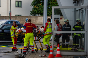 Rettungskräfte transportieren eine Person auf einer Trage in einem Einsatz.