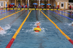 Schwimmer im Pool mit Bojen, Wettkampf im Gange.
