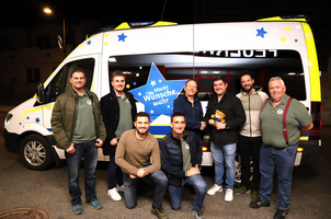 Eine Gruppe von Männern posiert vor einem Fahrzeug mit einem Stern-Logo.