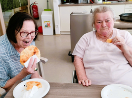 Zwei Frauen genießen zusammen Essen in einer gemütlichen Atmosphäre.