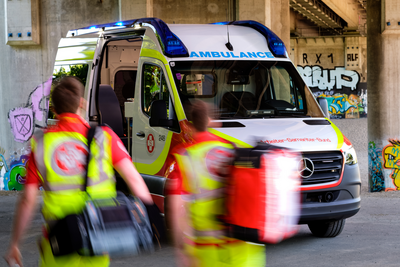 Rettungswagen mit Einsatzkräften unter einer Brücke.