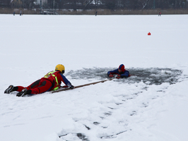 Rettungsschwimmer zieht eine Person aus einem Eisloch