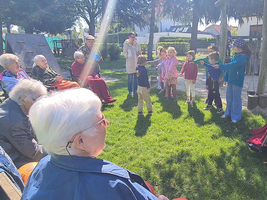 Ältere Menschen und Kinder interagieren im Freien während eines gemeinsamen Spiels.
