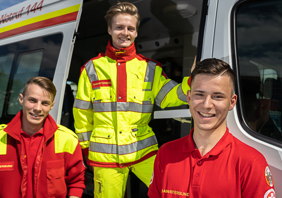 3 Zivildiener vor Samariterbund-Rettungswagen