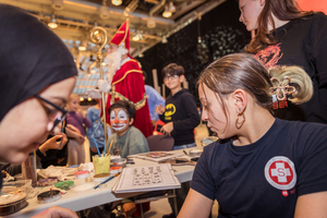 Kinder in Kostümen und Schminkutensilien bei einer festlichen Veranstaltung.