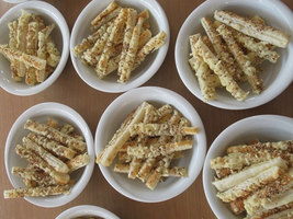 Geschmackvolle, knusprige Snacks in mehreren kleinen Schalen auf einem Tisch.