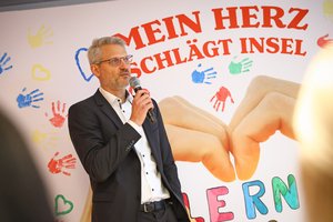 Oliver Löhlein, Geschäftsführer des Samariterbund Wiens, spricht vor DIF-Hintergrund in ein Mikrofon