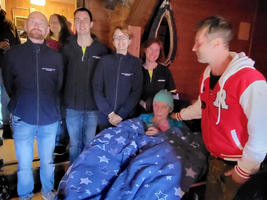 Eine Gruppe von Menschen versammelt sich um eine Person im Rollstuhl.