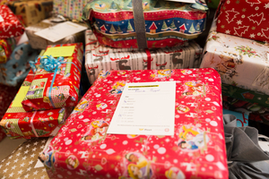 Geschenkpäckchen in buntem Papier mit einer Informationskarte darauf.