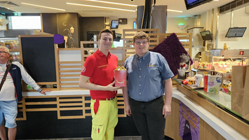 Ein Sanitäter und ein McDonald´s Mitarbeiter halten ein Happy Meal