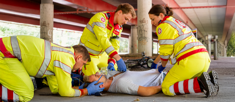 Eine Sanitäterin und ein Sanitäter vom Samariterbund versorgen eine verunglückten Fahradfahrer