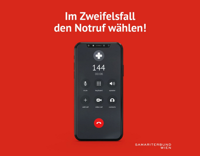 Handy mit der Notrufnummer 144 am Display vor rotem Hintergrund