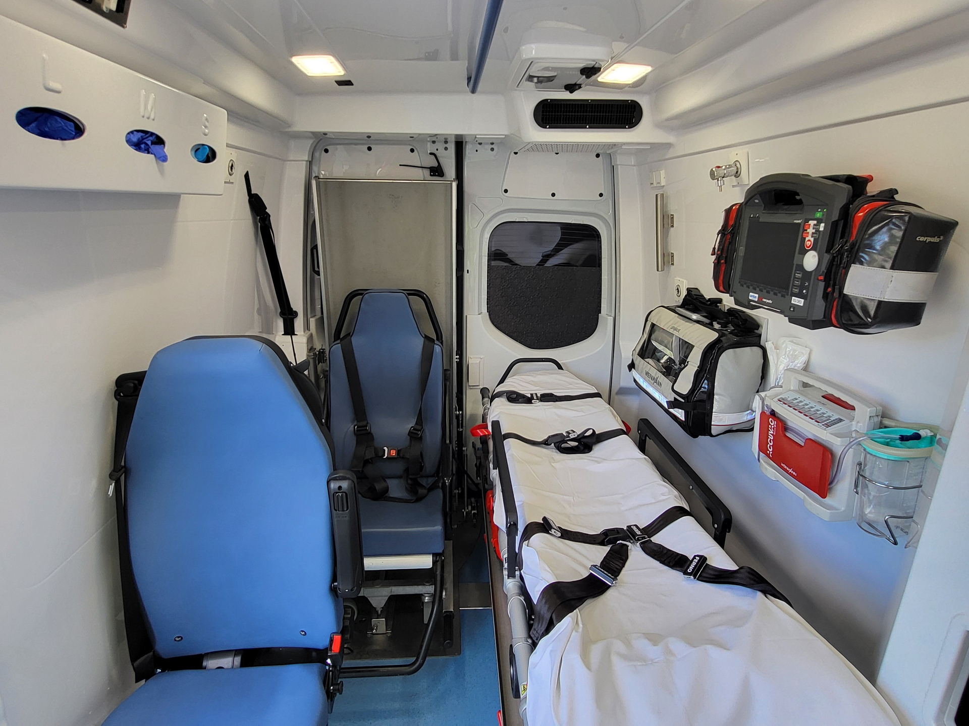 Innenansicht eines Krankenwagens mit einem Tragestuhl und medizinischer Ausrüstung.