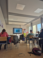 Lehrer präsentiert eine Präsentation in einem Klassenzimmer mit Sitzenden Schülern.