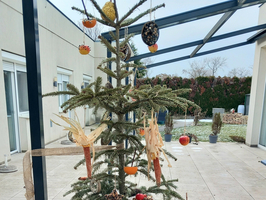 Ein geschmückter Weihnachtsbaum mit naturbelassenen Dekorationen im Freien.