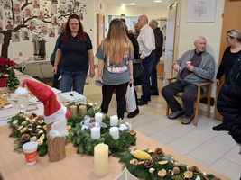 Menschen versammeln sich in einem festlich dekorierten Raum mit Weihnachtsgeschmück.