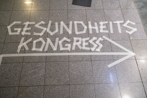 Pfeil aus Klebeband weist auf den Gesundheitskongress hin.