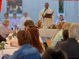 Ein Priester liest während einer Zeremonie vor einer versammelten Gruppe.
