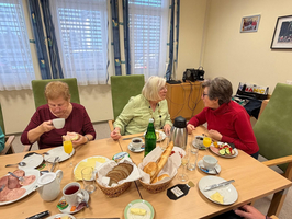 Drei Frauen sitzen an einem Tisch und genießen ein Frühstück zusammen.