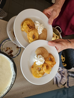 Zwei Teller mit gebackenen Apfelringen und Sahne.